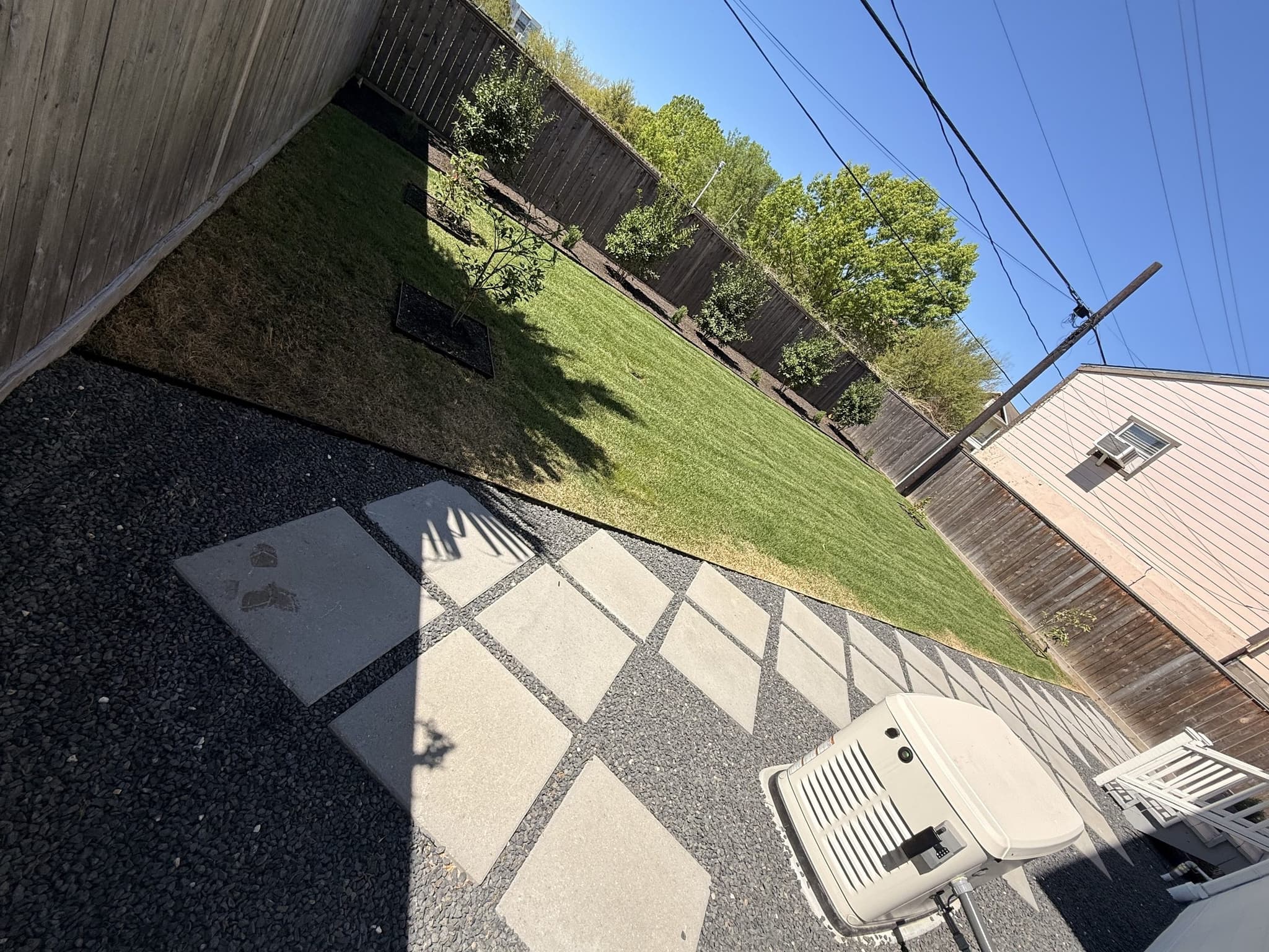 Pavers and a new base going in across a backyard during a full outdoor rebuild.