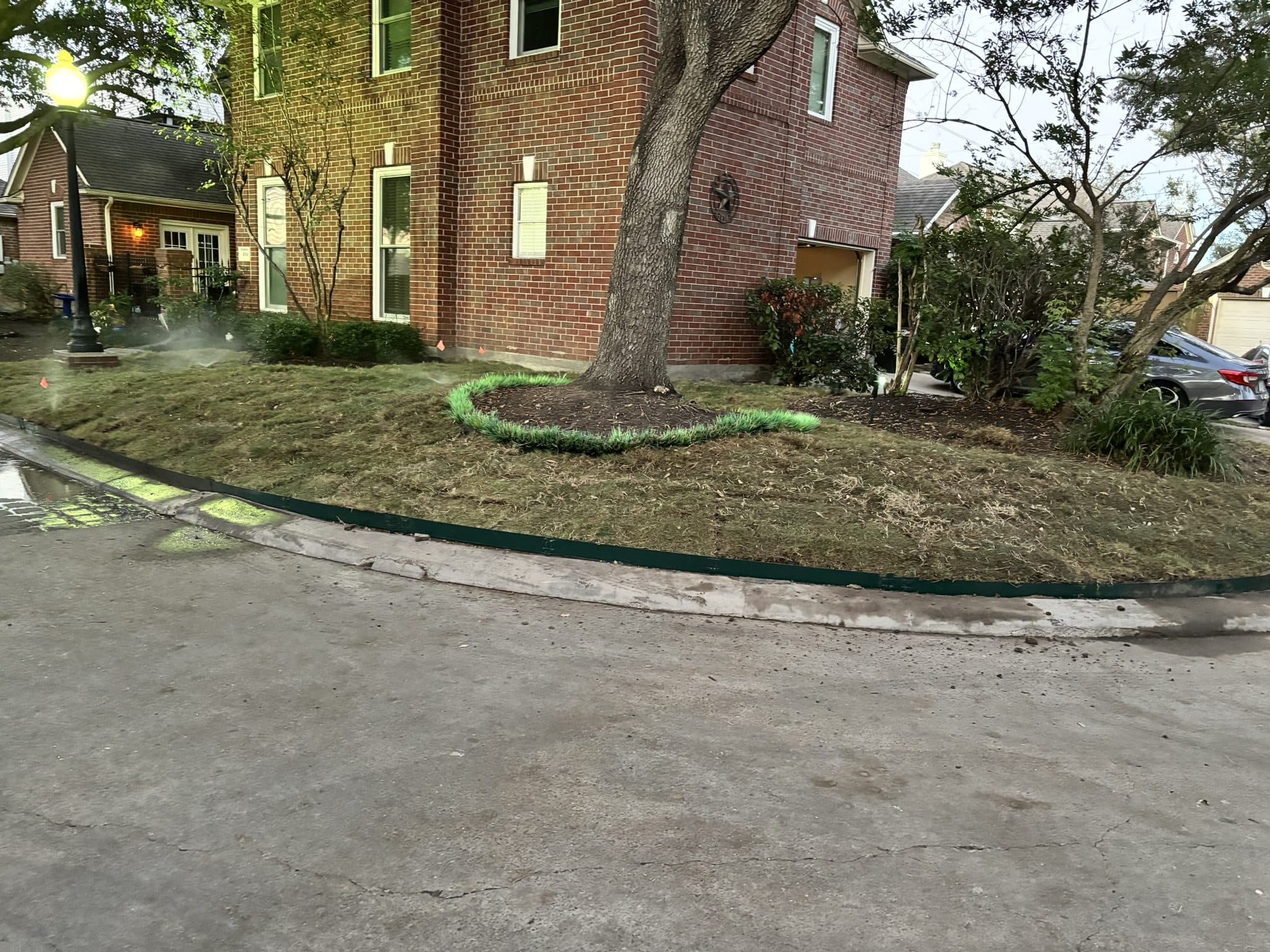 Marking paint laying out new bed lines and irrigation runs before installation begins.
