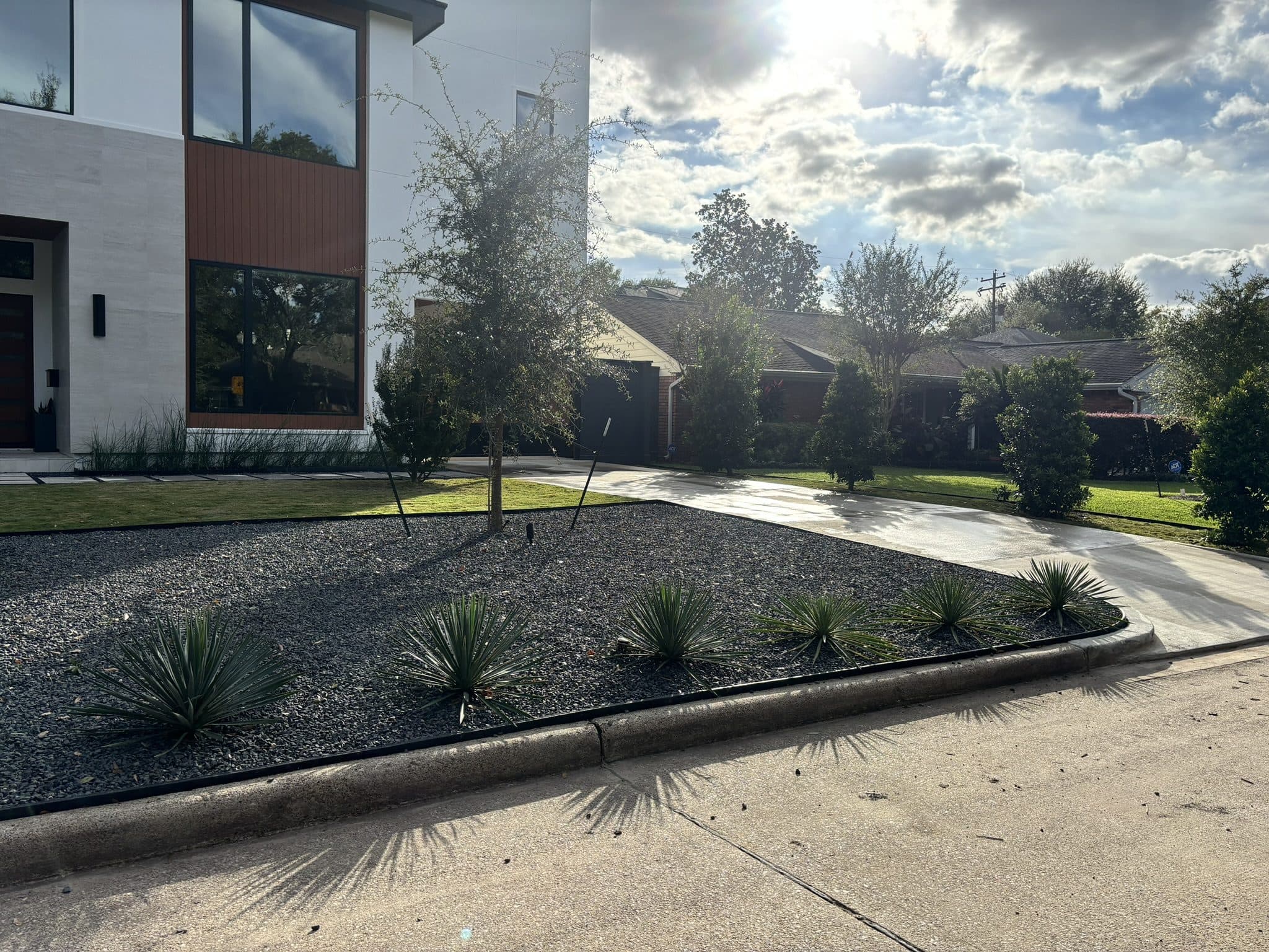 A gravel and grass streetscape treatment fronting a row of contemporary homes.