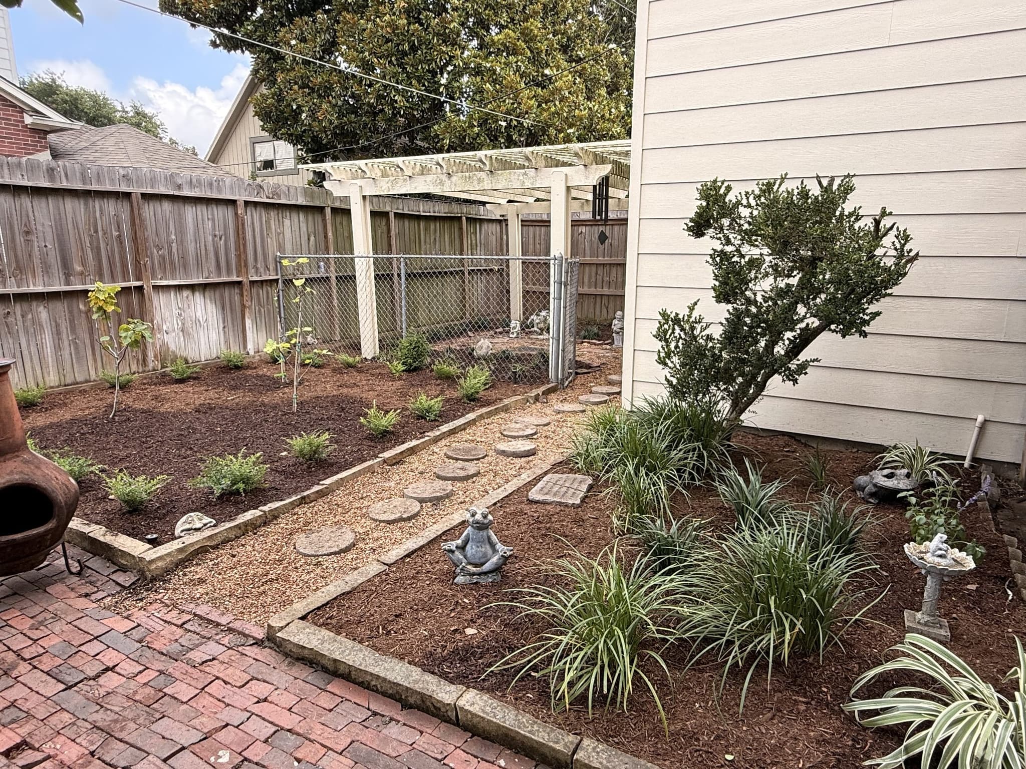 A side yard rebuilt with stepping stones, mulch beds and mixed ornamental planting.